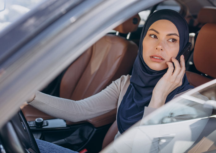 Woman in hijab in a car, feeling unsafe after a coworker rejected incident. Woman in hijab in a car, feeling unsafe after a coworker rejected incident.
