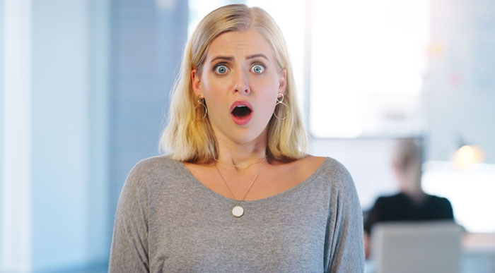 A woman with wide eyes and an open mouth expresses shock at a missing business sign video. A woman with wide eyes and an open mouth expresses shock at a missing business sign video.