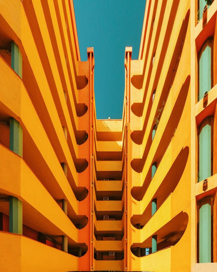 Architectural locations with striking yellow buildings and teal windows, against a bright blue sky.