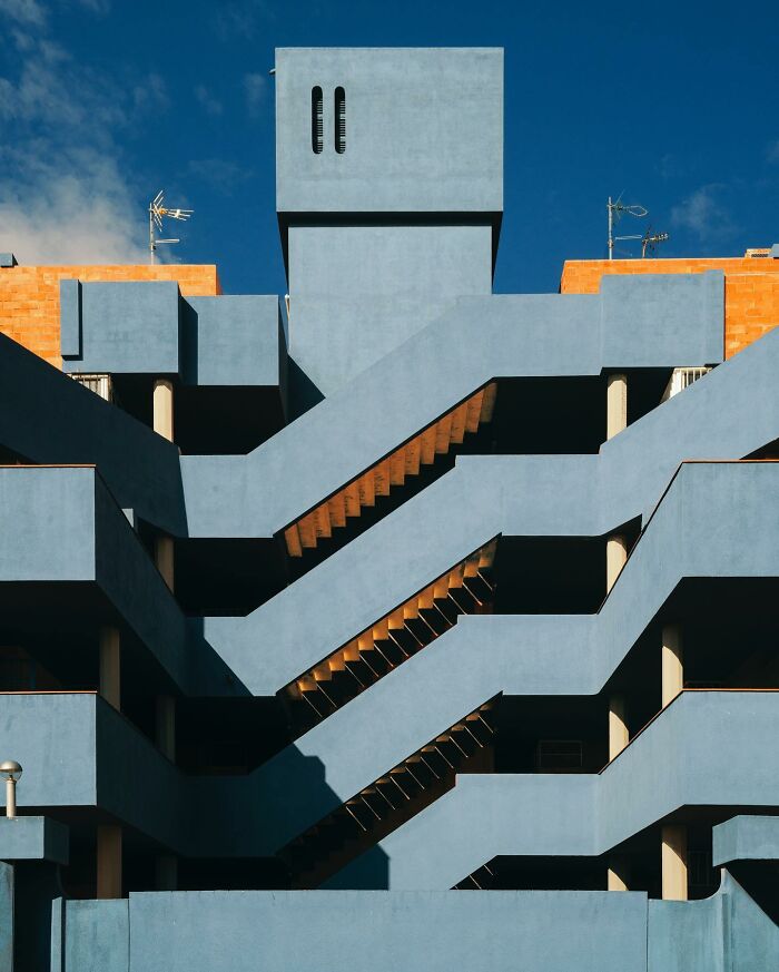 Architectural locations showing a blue building with unique exterior staircases and small windows.