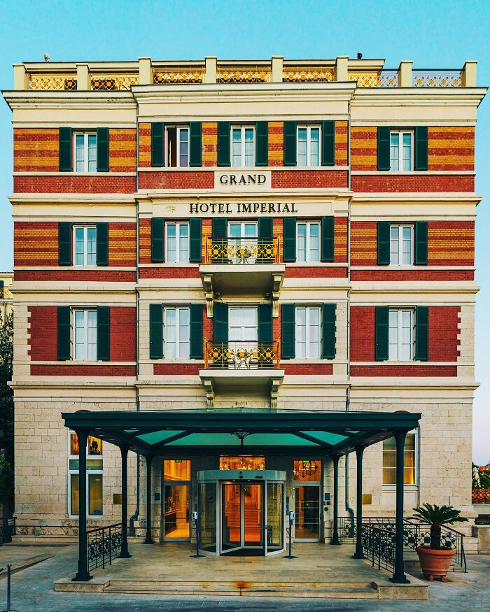 A photographer captures a perfectly composed image of the Grand Hotel Imperial, a historic architectural location.
