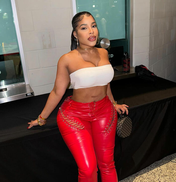 A woman in a white top and red pants, not the goth influencer. A woman in a white top and red pants, not the goth influencer.