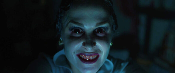 A terrifying woman with glowing red eyes and sharp teeth from a horror movie that tested as most terrifying.