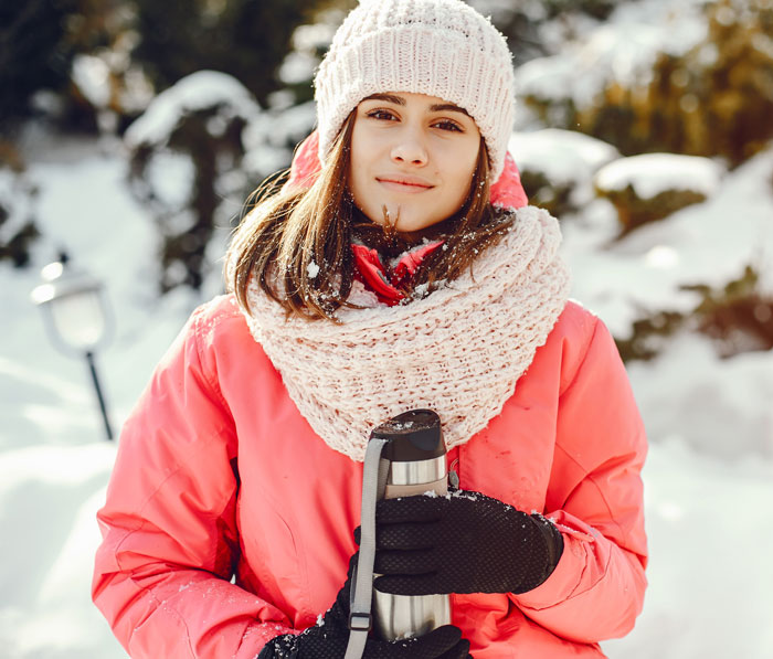 A woman guide leading an Arctic tour in snowy weather, holding a thermos, despite a Saudi Dad refusing due to her gender. A woman guide leading an Arctic tour in snowy weather, holding a thermos, despite a Saudi Dad refusing due to her gender.