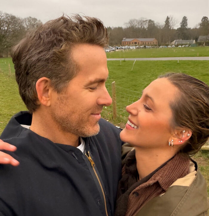 Ryan Reynolds and Blake Lively smiling outdoors, demonstrating why he isn't blacklisted despite Hollywood backlash.