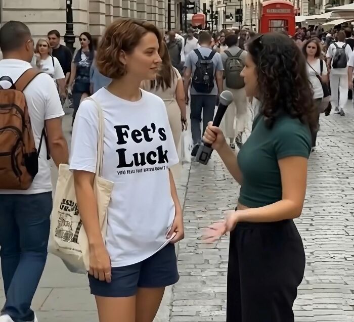 A woman wearing a 'Fet's Luck' t-shirt being interviewed on a busy street, featured in hilarious posts from Xavier.