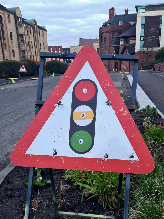 Absurd signs: A brilliant artist created a traffic light sign using billiard balls for the lights.