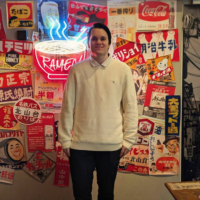 A man before attending Chinese fat camp, standing in front of a wall adorned with Japanese posters. A man before attending Chinese fat camp, standing in front of a wall adorned with Japanese posters.