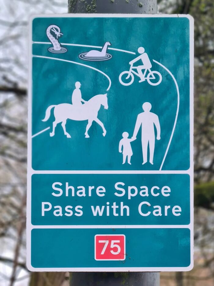 An absurd sign encouraging sharing space with people, bikes, horses, and sea monsters.