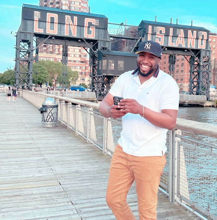 A happy dad standing outdoors near a body of water with 'LONG ISLAND' in the background, showing how child support backfired. A happy dad standing outdoors near a body of water with 'LONG ISLAND' in the background, showing how child support backfired.