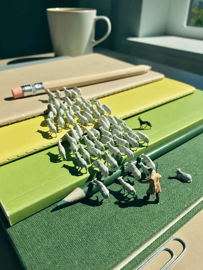 Artist Derrick Lin turns his office desk into intricate diorama sets, depicting a flock of sheep on a desk with a shepherd.