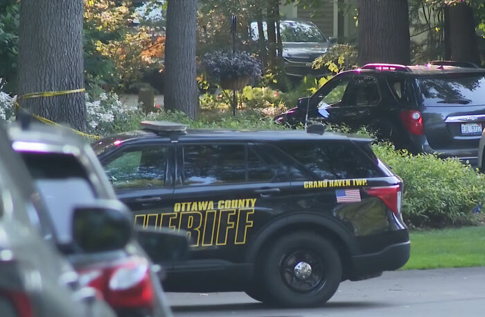 An Ottawa County Sheriff vehicle parked at the scene of the Michigan family tragedy, emphasizing the investigation.