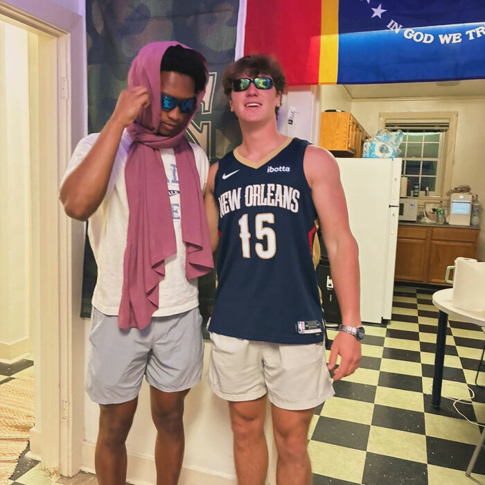 Nolan Wells' best friend and another young man posing in casual attire, with a flag background. Nolan Wells' best friend and another young man posing in casual attire, with a flag background.