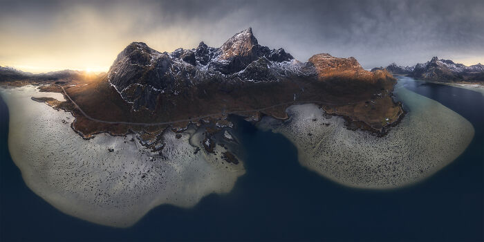 Spectacular aerial photograph showcasing a rugged mountain range bordering a unique coastal landscape.