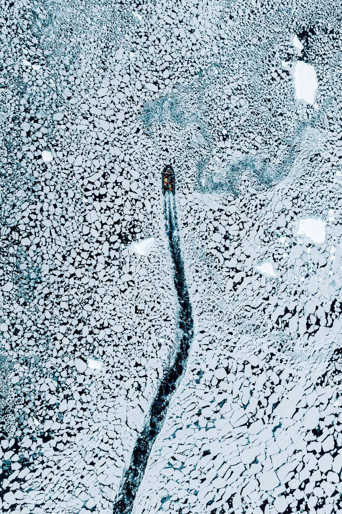 Spectacular aerial photograph of a boat breaking a path through an expanse of sea ice, awarded at the Aerial Photographer of the Year competition.