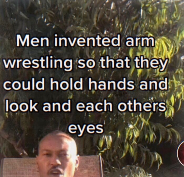 A humorous and relatable meme suggesting men invented arm wrestling for intimacy, boosting morale.