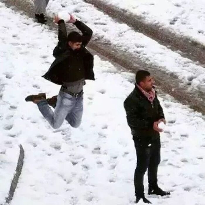 Two men in the snow, one mid-air about to throw a snowball, in funny photos taken before disaster.