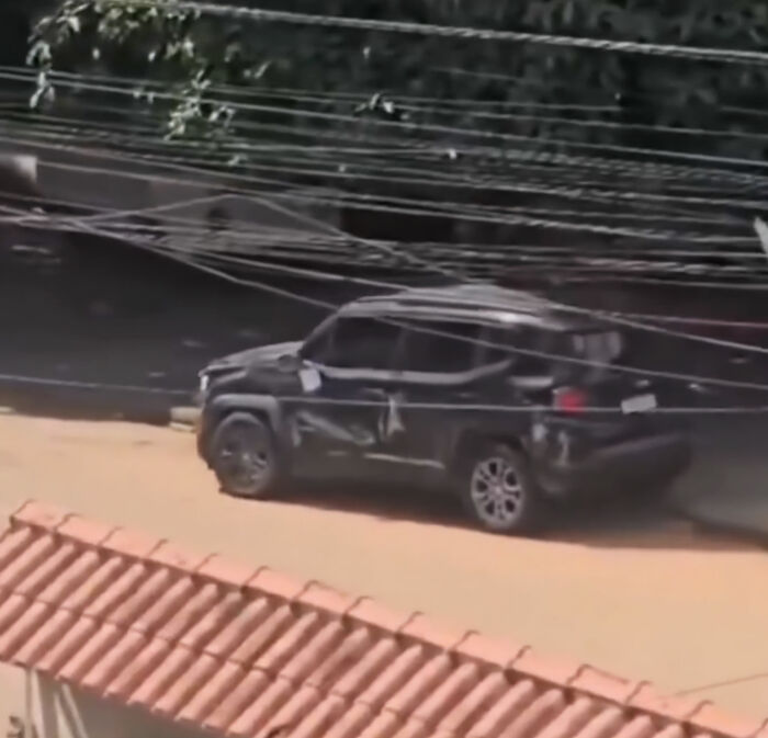 Black SUV damaged on side on a dirt road