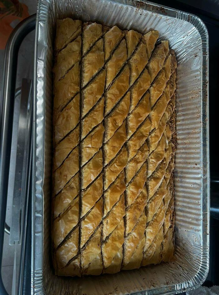 A large baking pan filled with golden-brown, diamond-cut baklava treats.