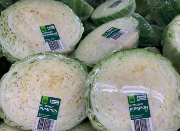 Several heads of cabbage incorrectly labeled as butternut pumpkin in a grocery store, showcasing a one job fail.