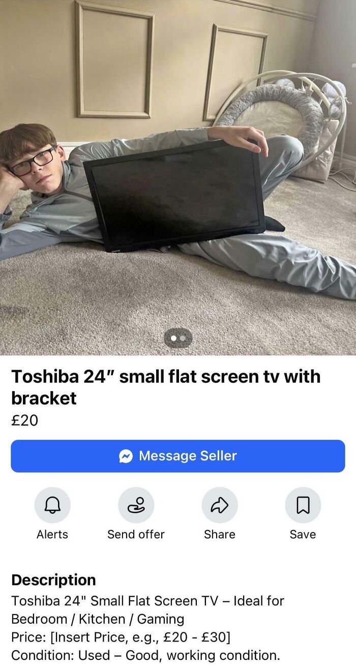 A person lying on the floor, awkwardly holding a small flat screen TV for a marketplace listing photo.