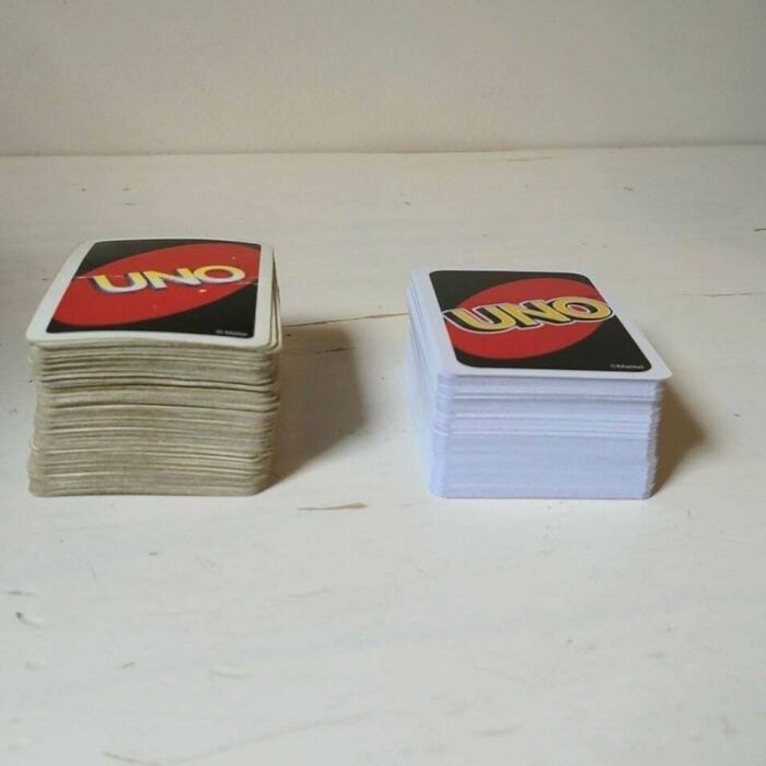A before-and-after photo of two stacks of UNO cards, one new and one old, showing how much things can change.
