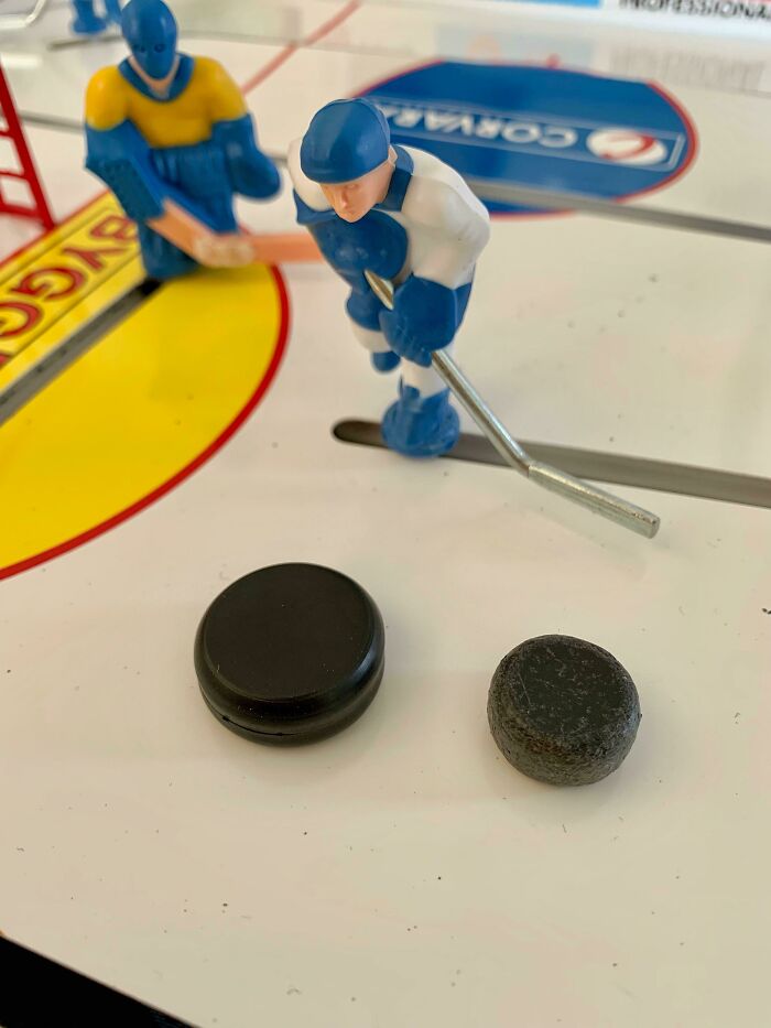 A before-and-after photo of two hockey pucks from a table hockey game, showing how much things can change.