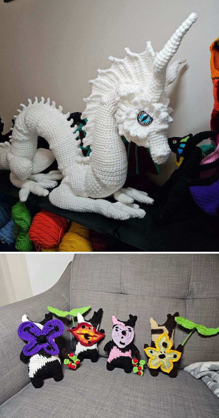 A large, intricately crocheted white dragon sits on a surface, next to smaller colorful crochet pieces, highlighting incredible crochet art.