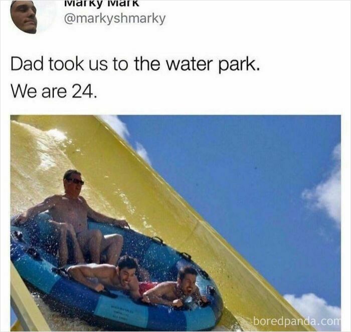 Three men, including a father and his adult sons, smile while riding a water slide together on an inner tube, soul-healing.