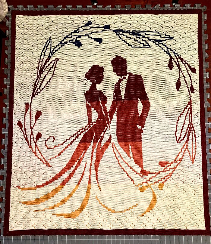 An intricately designed crochet blanket featuring silhouettes of a bride and groom, a stunning piece by a crochet enthusiast.