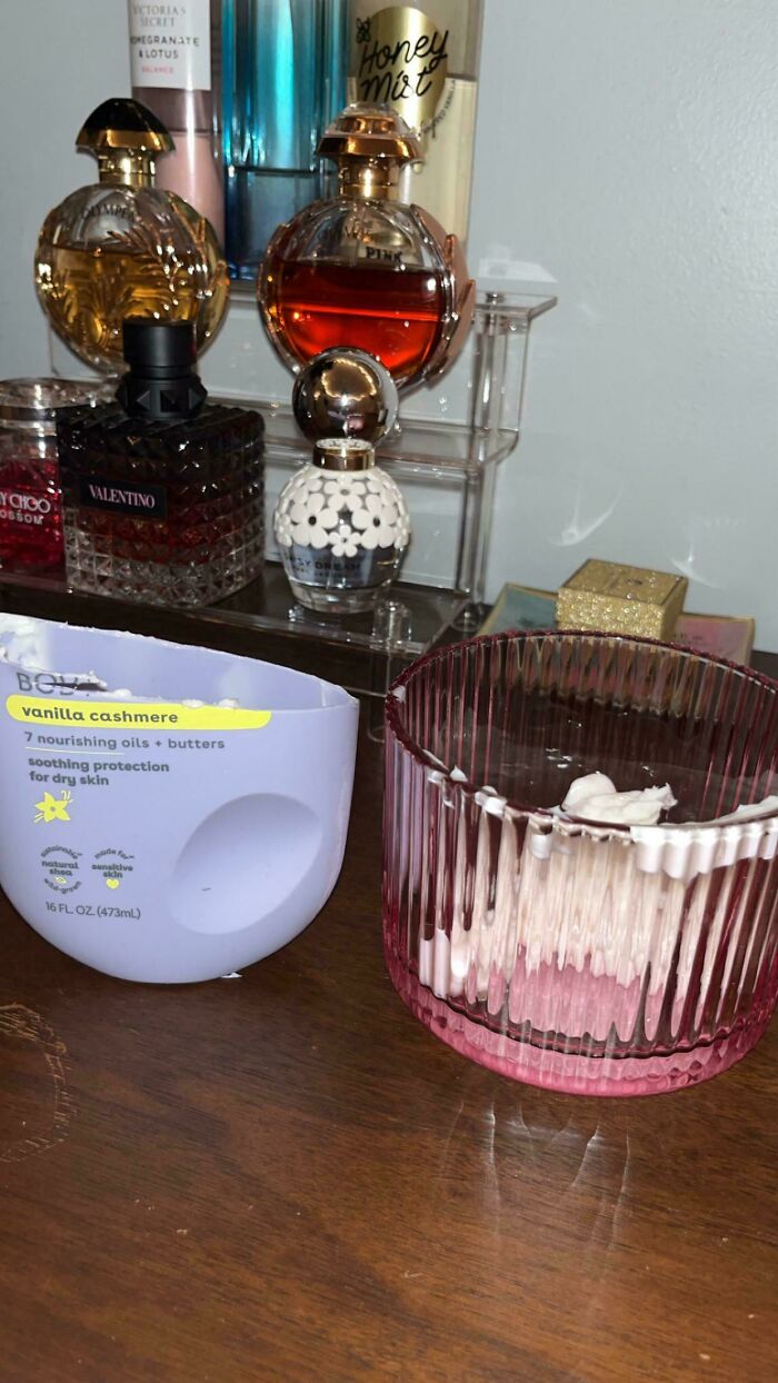 A half-used lotion bottle next to a candle, hinting at the impacts of consumerism and potential price differences.