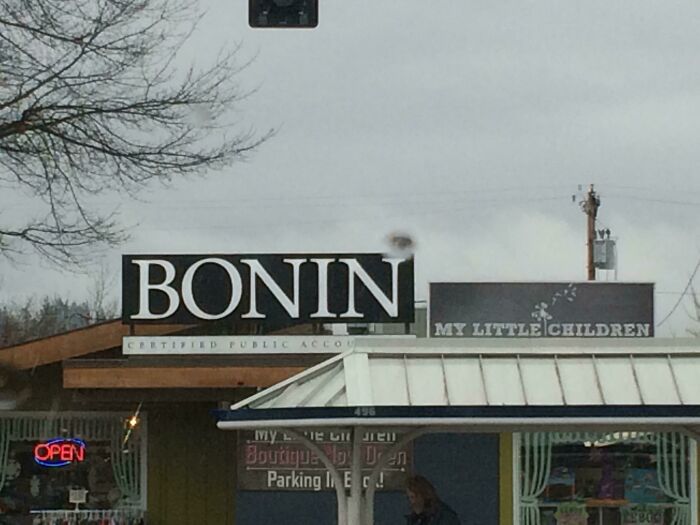 A store sign for Bonin Certified Public Accountants next to a shop named My Little Children, highlighting designers failing.