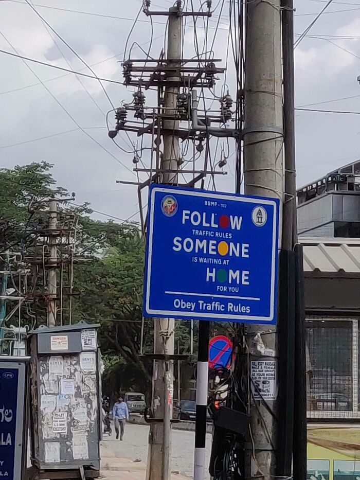A blue traffic rules sign with the word FOLLOW split by an image, demonstrating a design fail.