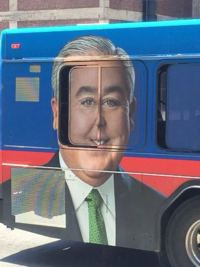 A bus advertisement with a man's face misaligned by a window, showing designers failed dismally.