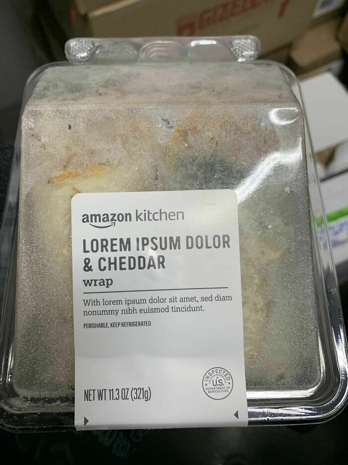 A molded Amazon Kitchen Lorem Ipsum Dolor & Cheddar wrap in a plastic container, showcasing a designer's oversight.