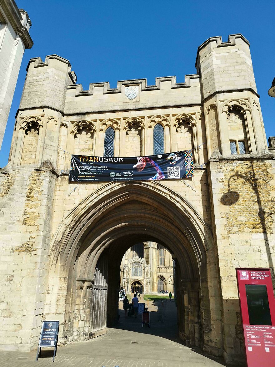 Grand stone entrance of an interesting castle or cathedral, with an arched gateway and towering turrets.