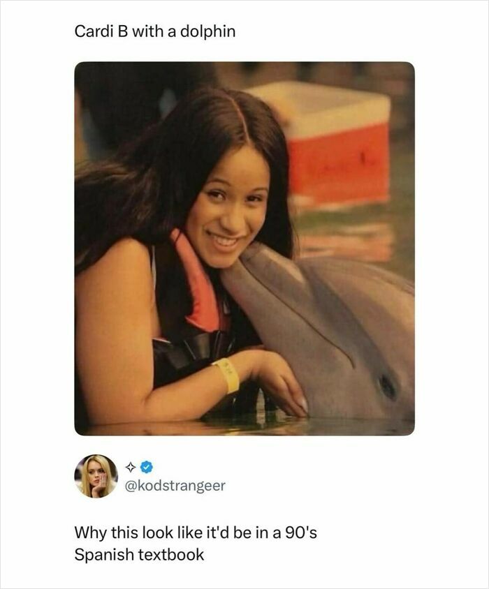 Cardi B smiling while hugging a dolphin in the water, a pop culture post for instant good vibes.