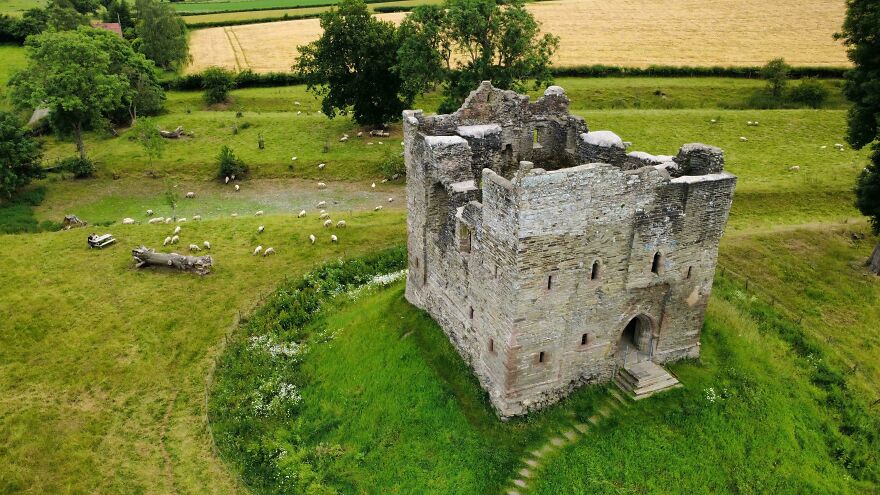 Interesting castles, ancient castle ruins on a grassy hill surrounded by green fields.