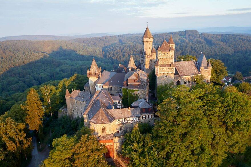 Beautiful German castle nestled in a lush green forest, an interesting sight among the rolling hills.