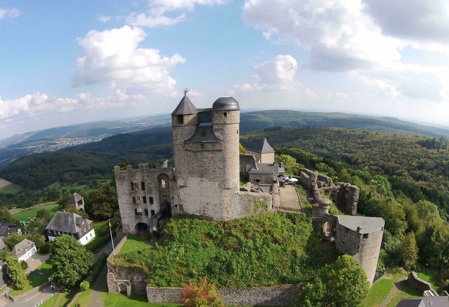 Beautiful and interesting stone castle ruins on a hilltop, offering panoramic views of the surrounding green landscape.
