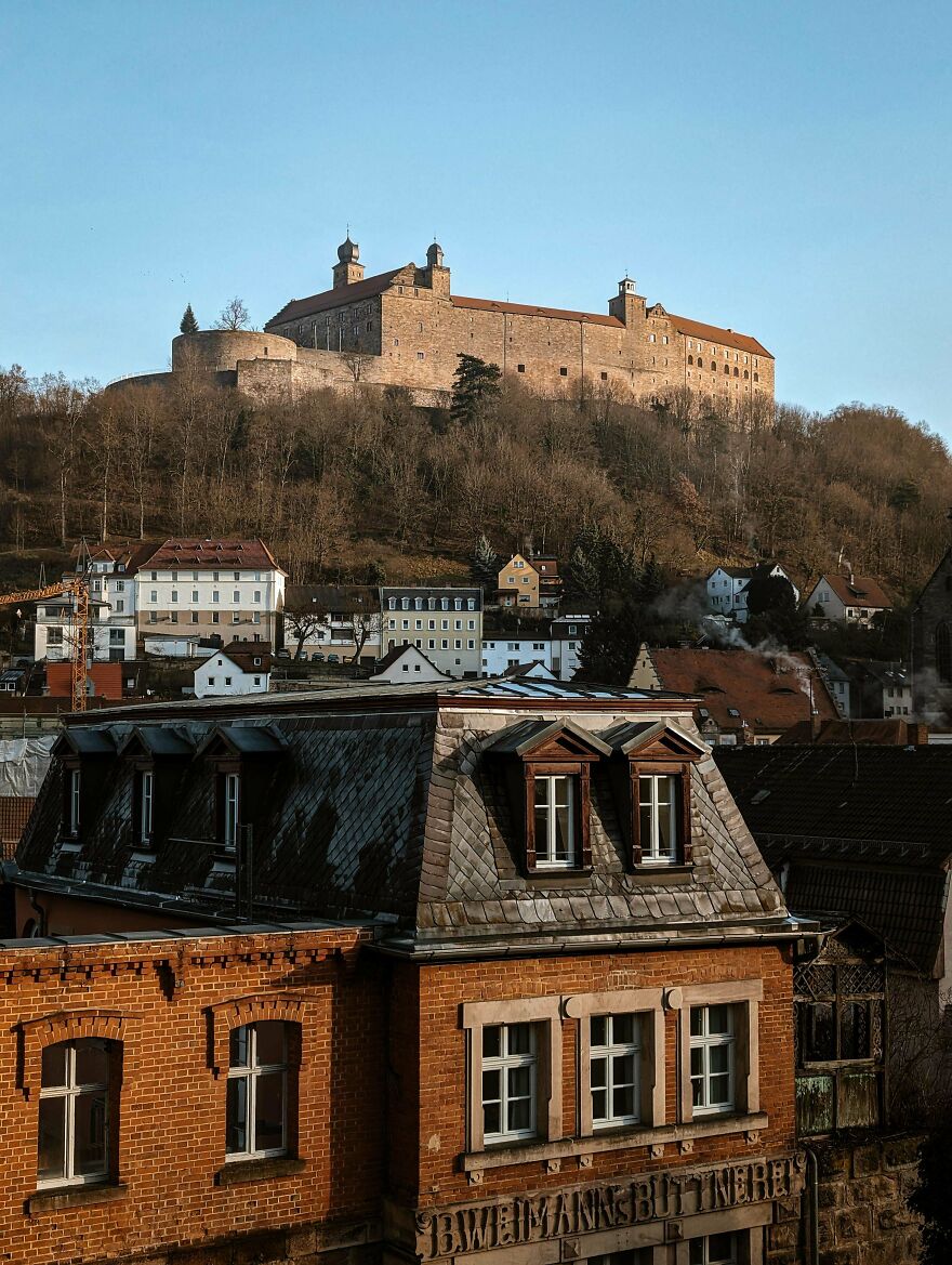 Beautiful castle atop a hill overlooking a town, an interesting photo of castles.