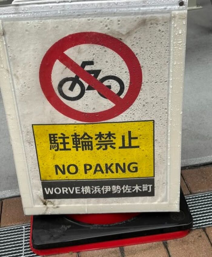 A sign in Japan with a bicycle crossed out, displaying a hilarious example of getting lost in translation: NO PAKNG.