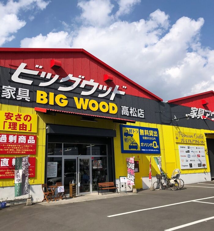 The exterior of a bright yellow and red store named Big Wood in Japan. An example of getting lost in translation.