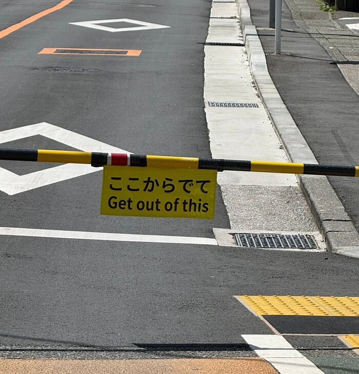 A yellow sign with the phrase Get out of this as an example of getting lost in translation in Japan.