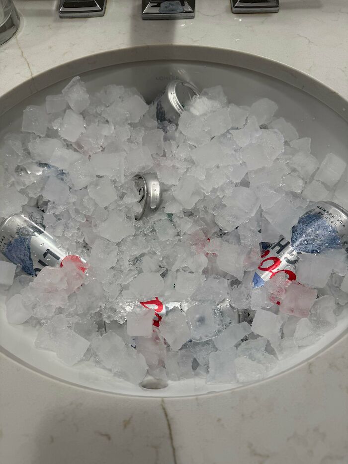 Beer cans chilling in a sink full of ice, an example of clever solutions.