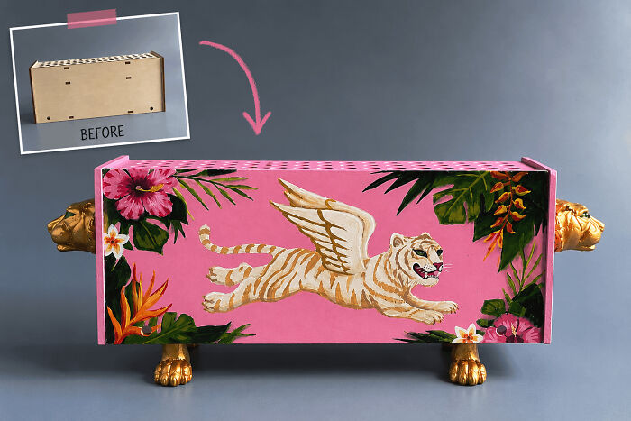 A handmade wooden box transformed with pink paint, a flying tiger, and golden lion feet, showcasing a talented project.