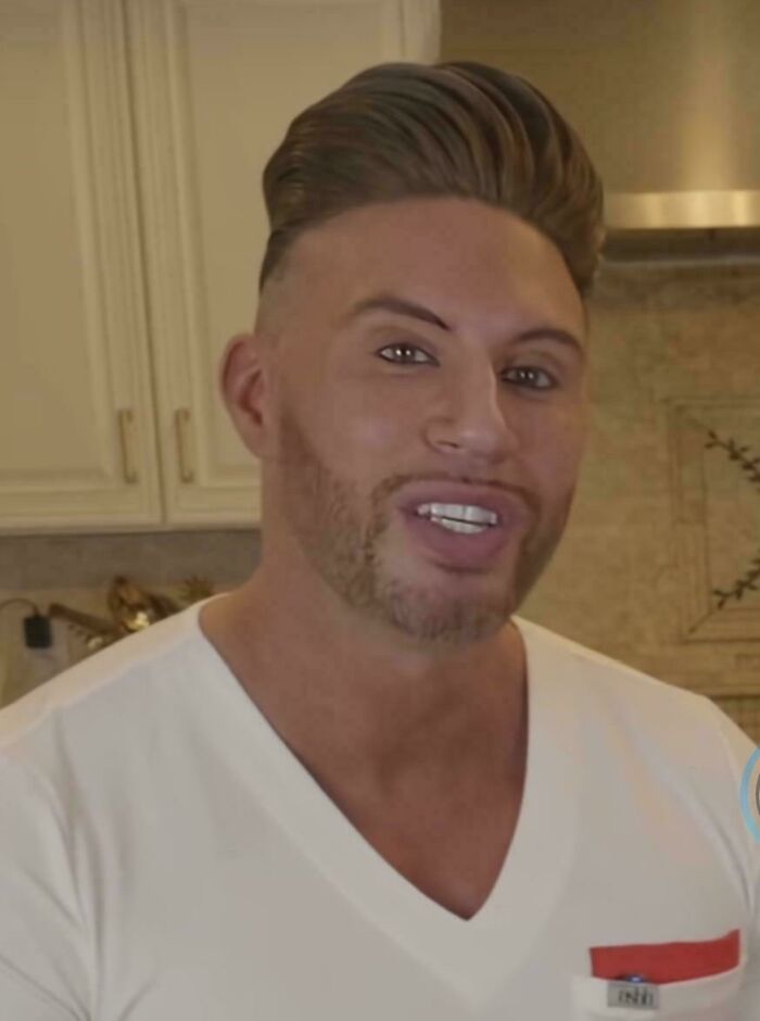 A man with a highly stylized, seemingly plastic, and bad hair mistake, smiling for the camera.