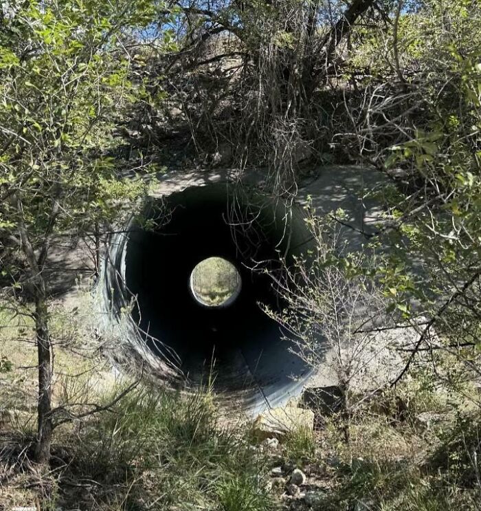 A large pipe opening appears to be a black circle with a smaller white circle in the middle, creating an optical illusion.