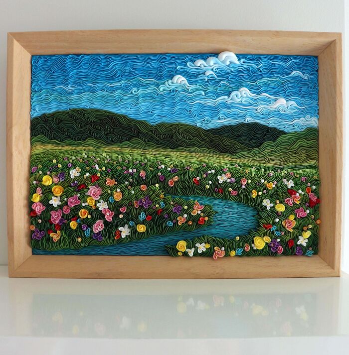 Framed 3D paper quilling art depicting a vibrant field of flowers and a river, an intricate handmade project.
