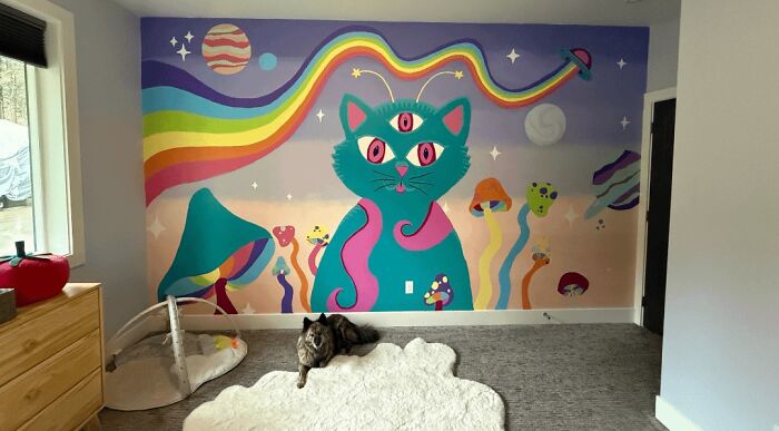 A handmade psychedelic wall mural with a cat, mushrooms, and a rainbow, a large artistic project.